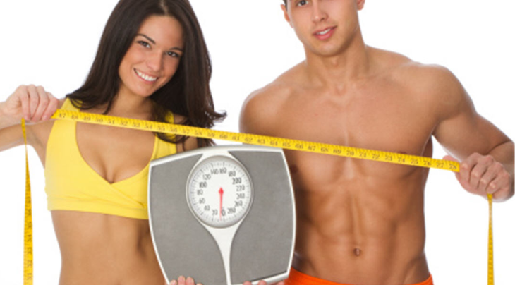 fit couple holding scale